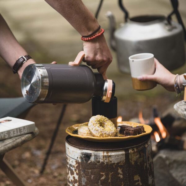 Kampeerder gebruikt Rebel Outdoor Thermoskan op de camping
